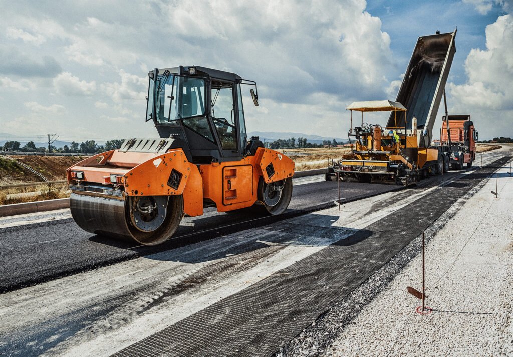 Two pieces of heavy machinery used for road construction.