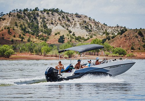 A group of people ride in a boat on a lake.
