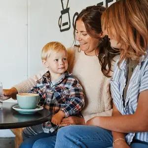 Two women sit together with a small child