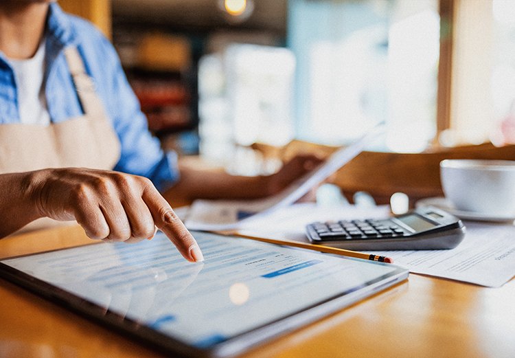 A woman uses the touchscreen on a tablet.